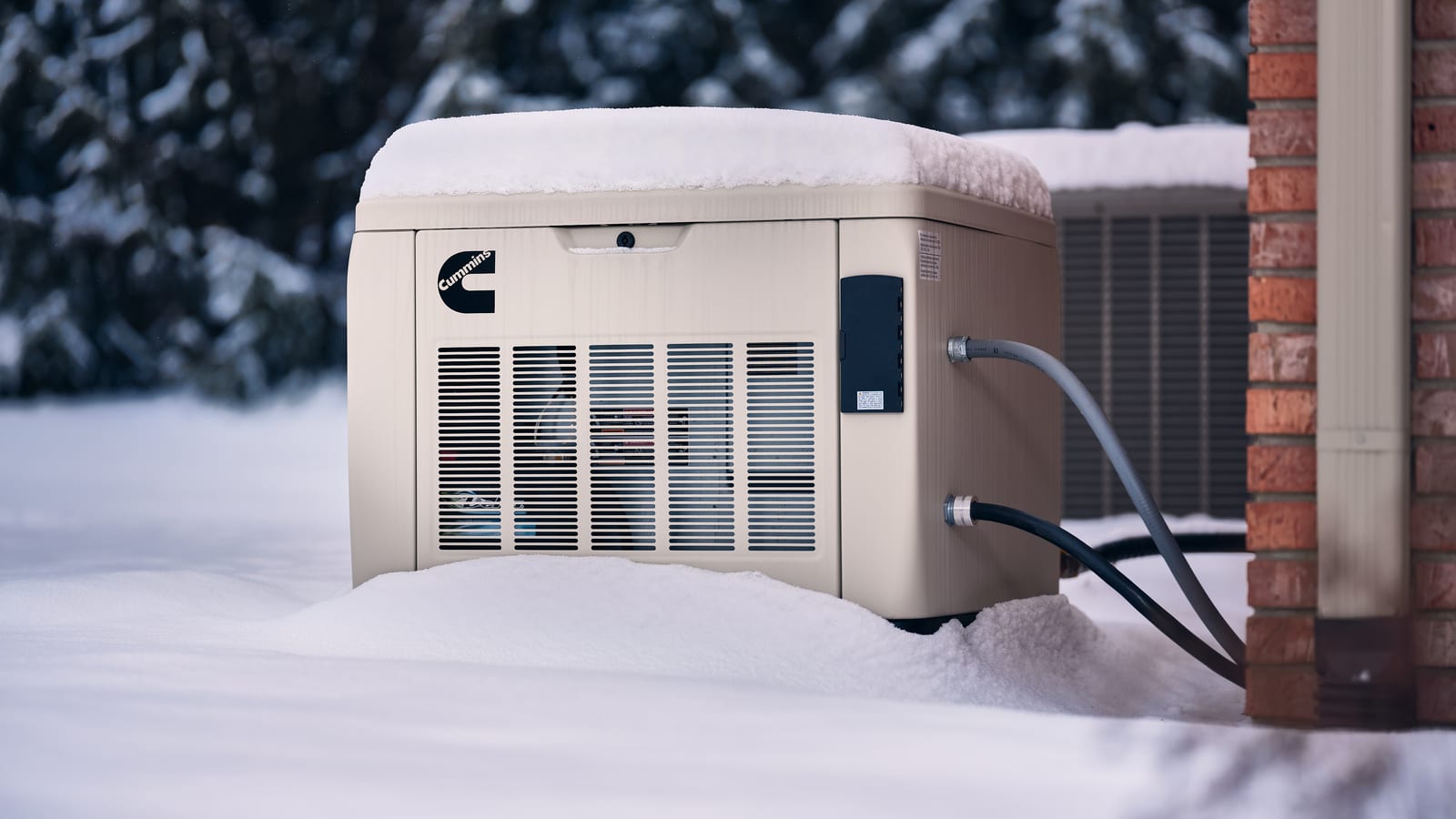 Cummins home standby generator running in snow beside a house