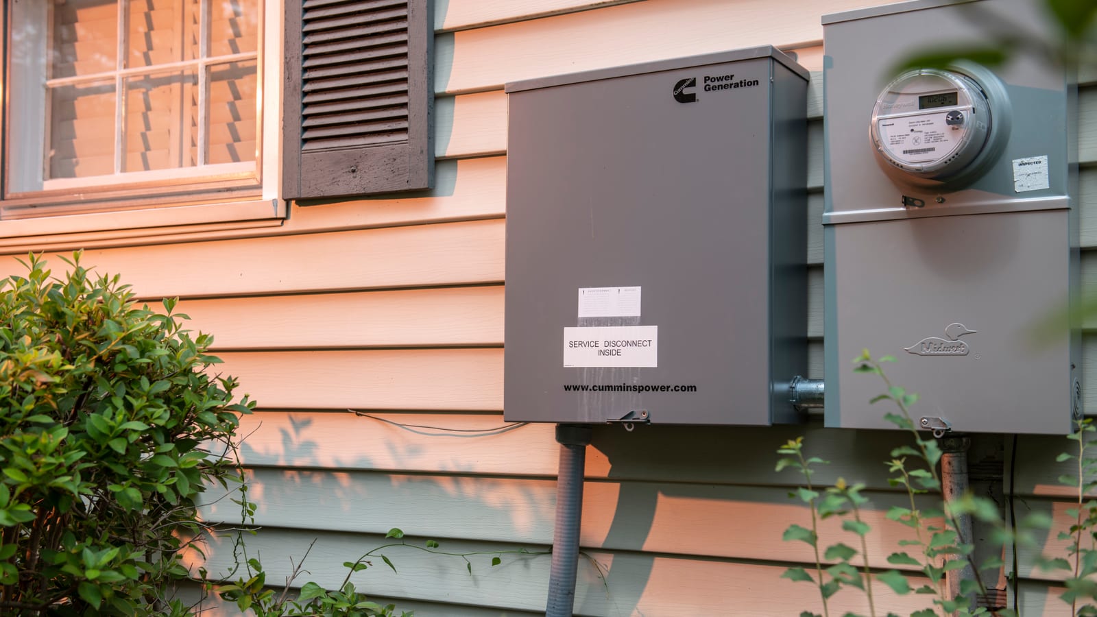 Service disconnect and meter beside a Cummins home standby installation